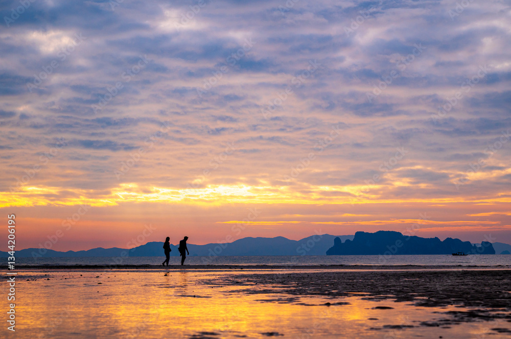 tourist watching sunset or sunrise on beach with seascape and gold lighting sunset sky background