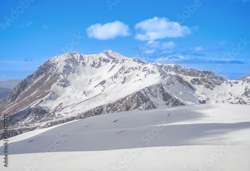 Ovindoli (Abruzzo, Italy) - The Monte della Magnola is a imponent and suggestive mountain peak in Abruzzo, above the ski resorts of Ovindoli, here during the winter with snow and alpinists. photo
