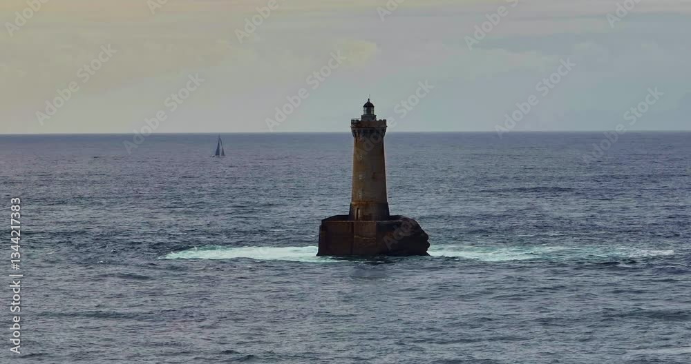 A rotating overhead shot of Phare du Four a lighthouse in Bretagne France. An ancient one standing far from the shore in the ocean and the first to meet huge waves A rotating overhead shot of Phare du Four a lighthouse in Bretagne France. An ancient one standing far from the shore in the ocean and the first to meet huge waves