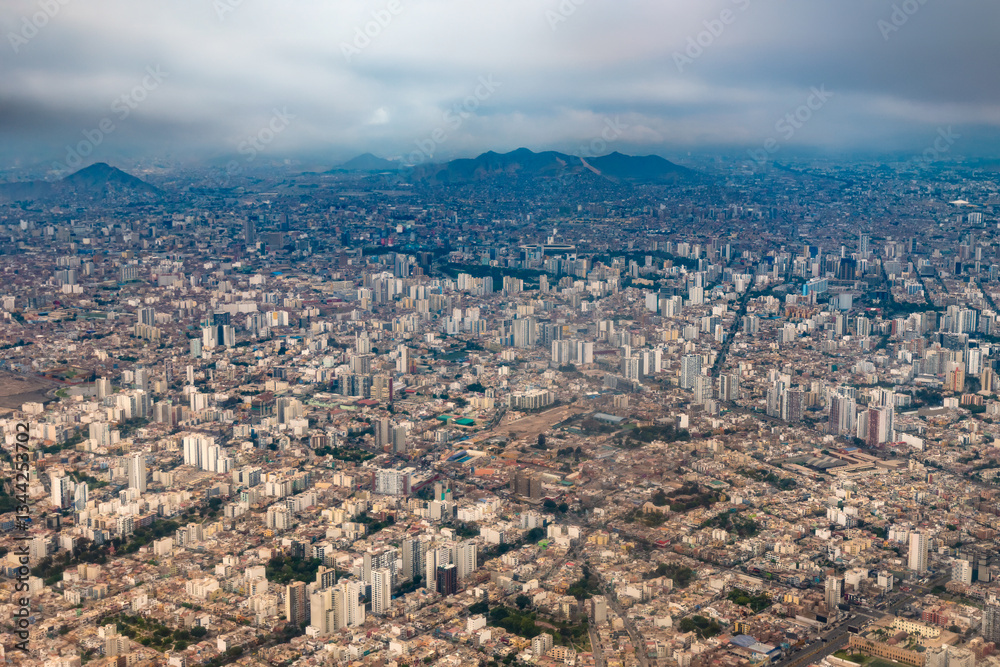 Obraz premium A sweeping aerial perspective highlights the vast urban sprawl of Lima, where modern architecture coexists with neighborhoods.