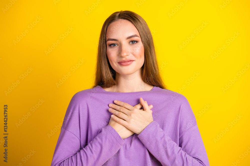 Charming Young Woman Smiling in a Casual Purple Shirt Against a Bright Yellow Background