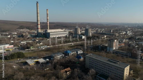 Aerial view of high voltage power lines with a thermal power plant chimneys and a busy street with cars in Chișinau