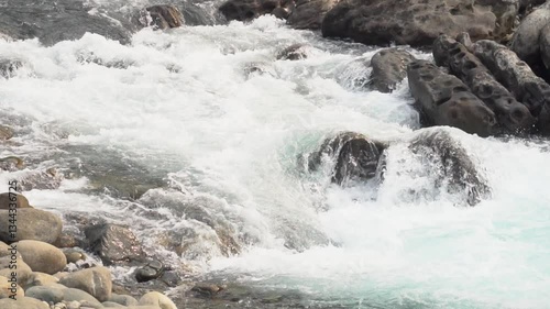 Slow motion video of water flowing through rocky landscape