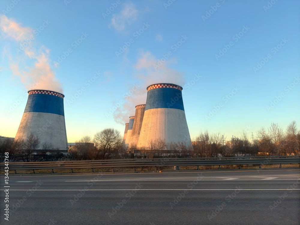 The heating plant pipes along the roadway release abundant steam from both thin and thick pipes on a sunny day with a blue sky The heating plant pipes along the roadway release abundant steam from both thin and thick pipes on a sunny day with a blue sky