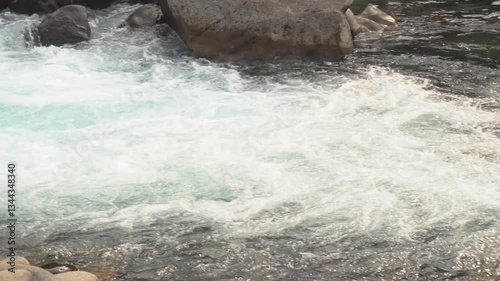 Slow motion video of water flowing through rocky landscape