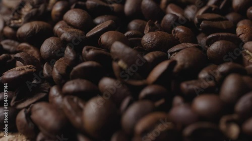 In the shot, black coffee beans on a wooden plate, rotating slowly