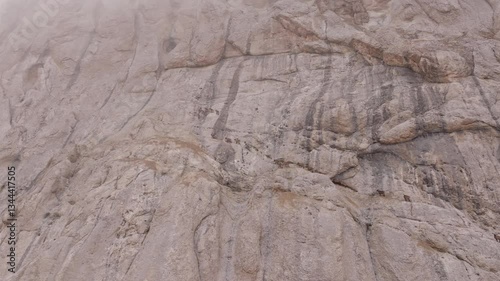 Wallpaper Mural Impressive aerial view of a steep, rocky mountainside, partially obscured by clouds, highlighting its rugged texture and imposing presence in nature Torontodigital.ca