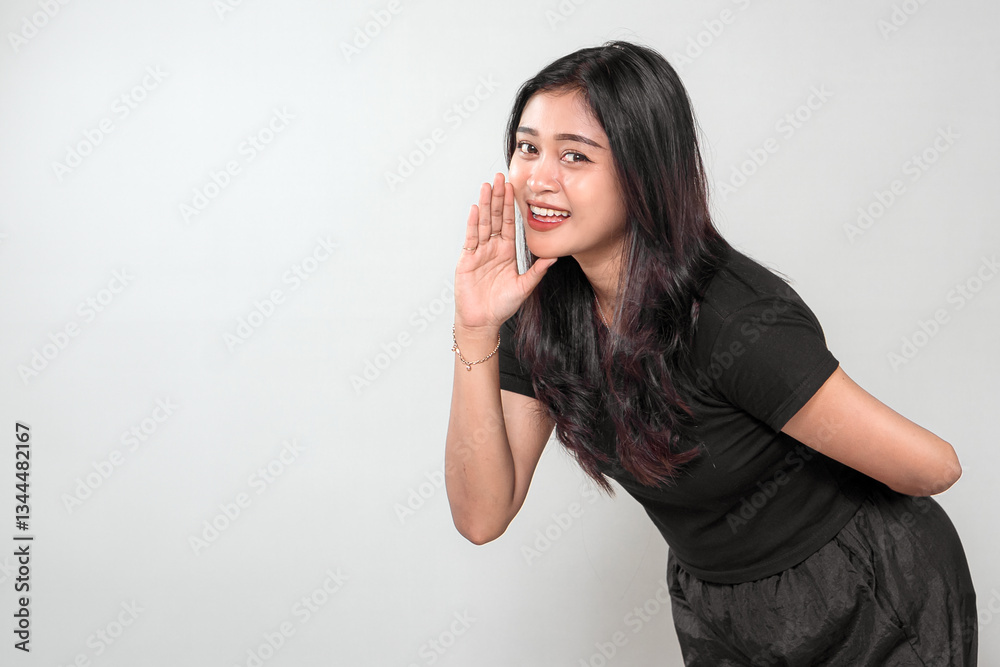 A cheerful Indonesian woman with long black hair wearing a black outfit, playfully whispering with a smile. She poses with a joyful and friendly expression. A cheerful Indonesian woman with long black hair wearing a black outfit, playfully whispering with a smile. She poses with a joyful and friendly expression.
