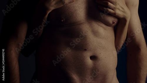 Female hand touching male muscular torso. Slow motion