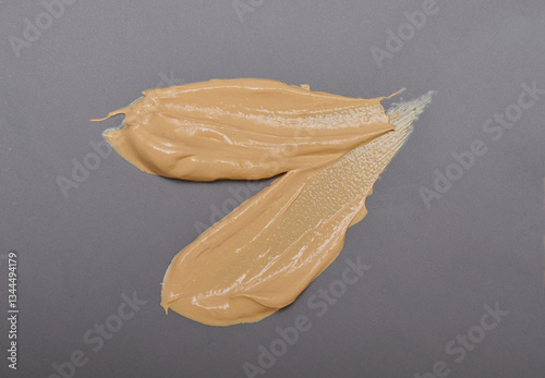 Obraz na płótnie Light pale brown yellow gold color cosmetic cream texture. Lotion smear. Creamy skincare product swatch isolated gray background. w salonie