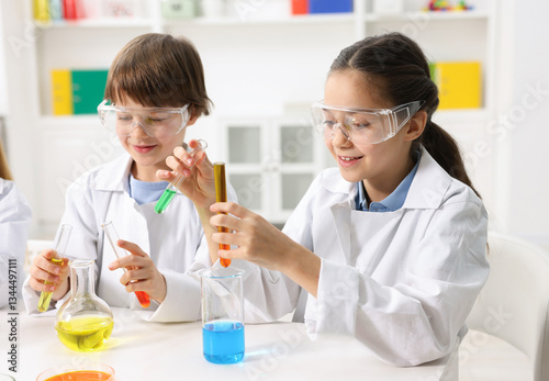 Fotografia Children doing chemical experiment at desk indoors