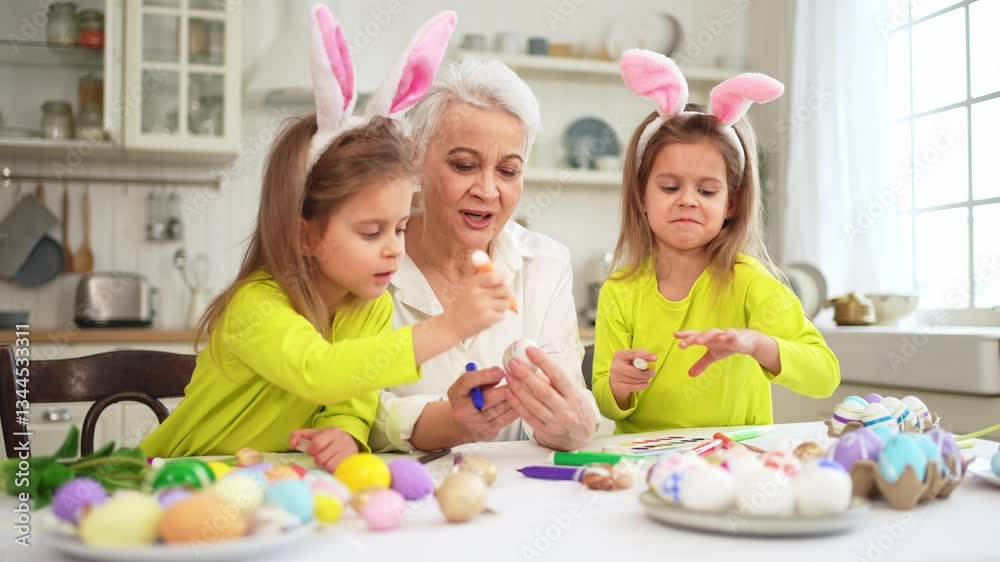Happy Easter. Two little girls sisters twins grandmother painting eggs enjoying time together. Happy family grandma granddaughters child kids preparing for Easter. Spring Christian festival tradition Happy Easter. Two little girls sisters twins grandmother painting eggs enjoying time together. Happy family grandma granddaughters child kids preparing for Easter. Spring Christian festival tradition