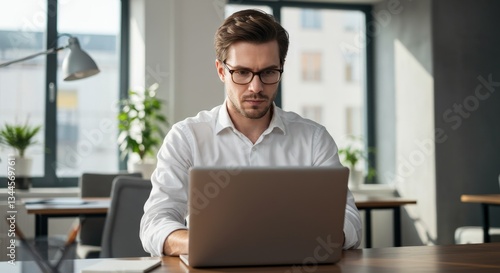 Remote worker in a modern office setting using a laptop for professional tasks
