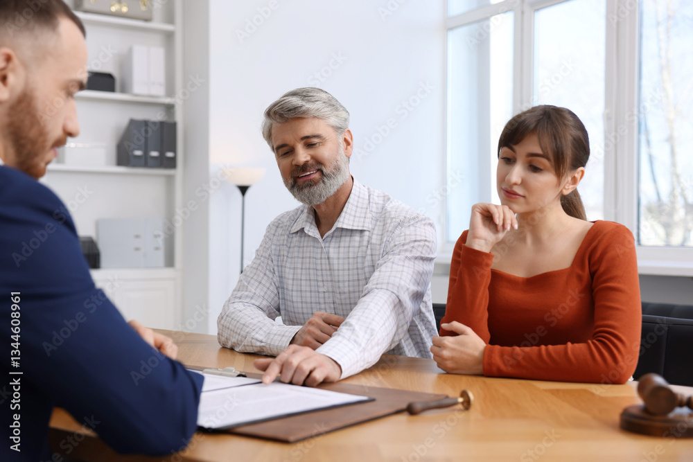 Couple having meeting with professional notary at wooden desk indoors Couple having meeting with professional notary at wooden desk indoors