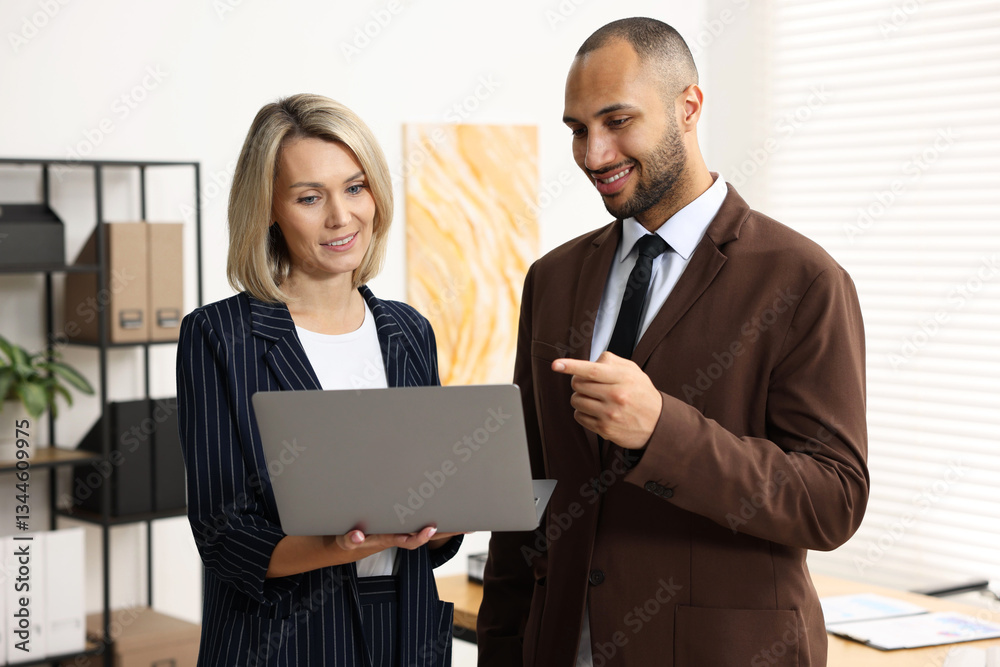 Coworkers with laptop working together in office Coworkers with laptop working together in office