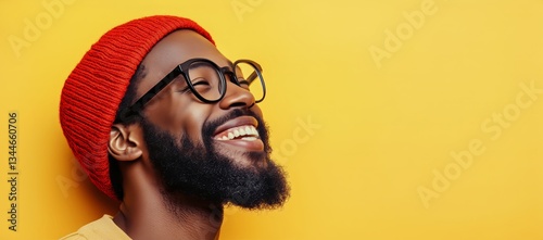 Man Smiling Joyfully Against Bright Yellow Background Wearing Glasses and a R...