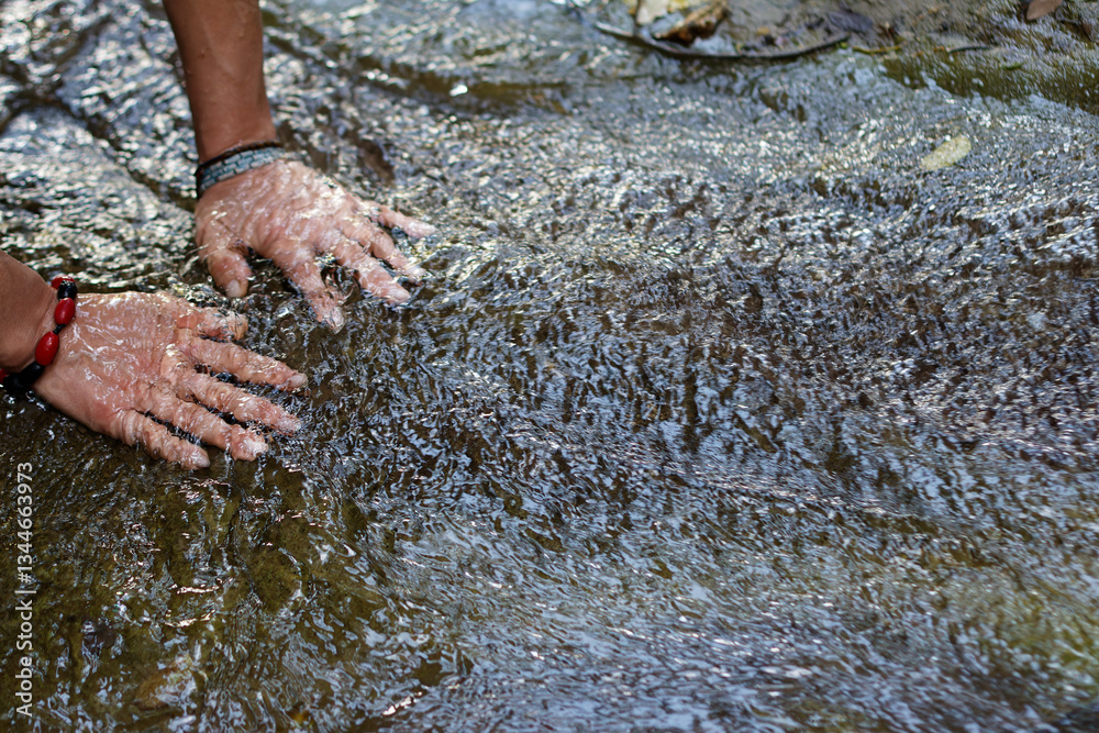Female Hands submerged in flowing stream of water in Villeta, Cundinamarca, Colombia. Close-up interaction with nature highlighting sensory experience