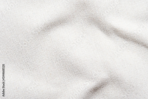 Close-up of textured white fabric with natural light and soft shadows.