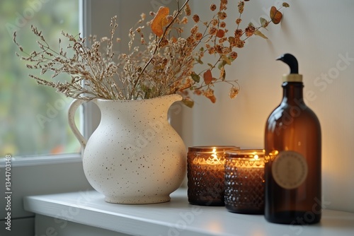 Decorative Vase With Dried Flowers and Candles on Windowsill During Soft Afte...