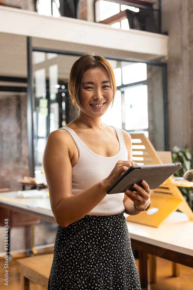 Smiling woman using digital tablet in modern office, embracing technology Smiling woman using digital tablet in modern office, embracing technology