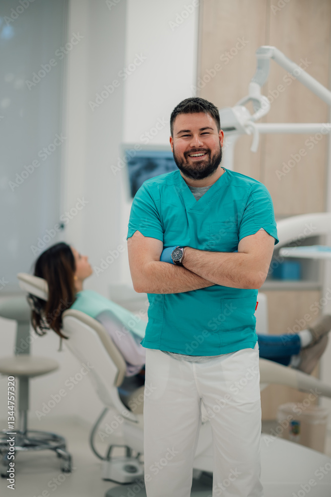 Obraz premium Portrait of smiling dentist posing with arms crossed in dental clinic