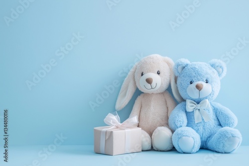 Soft plush toys blue bear and white bunny with gift box, blue studio wall, copy space