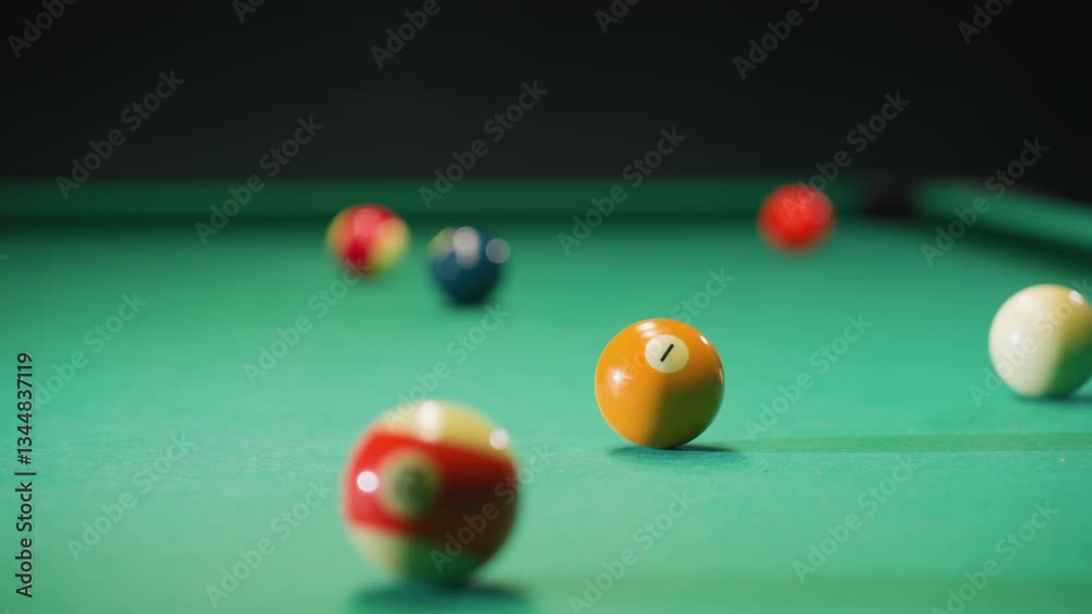 Close-up view of colorful billiard balls scattered on green pool table as white ball strikes orange ball. Vibrant scene captures movement, precision, and dynamic energy of strategic gameplay Close-up view of colorful billiard balls scattered on green pool table as white ball strikes orange ball. Vibrant scene captures movement, precision, and dynamic energy of strategic gameplay