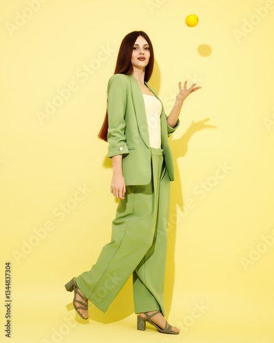 Obraz na płótnie Fashion portrait of beautiful model in green suit with lemons against yellow background w salonie