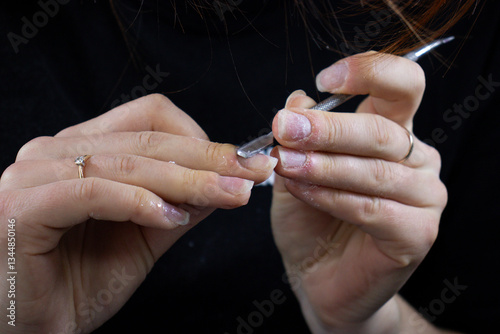 Nail Technician Using Electric Nail Drill for Manicure and Nail Care