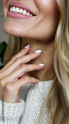 Smiling woman with elegant nails enjoying a cozy moment indoors in natural light