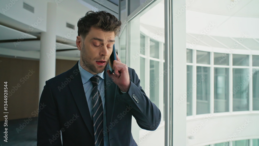 Stylish ceo speaking cellphone near office panoramic window closeup. Man calling Stylish ceo speaking cellphone near office panoramic window closeup. Man calling