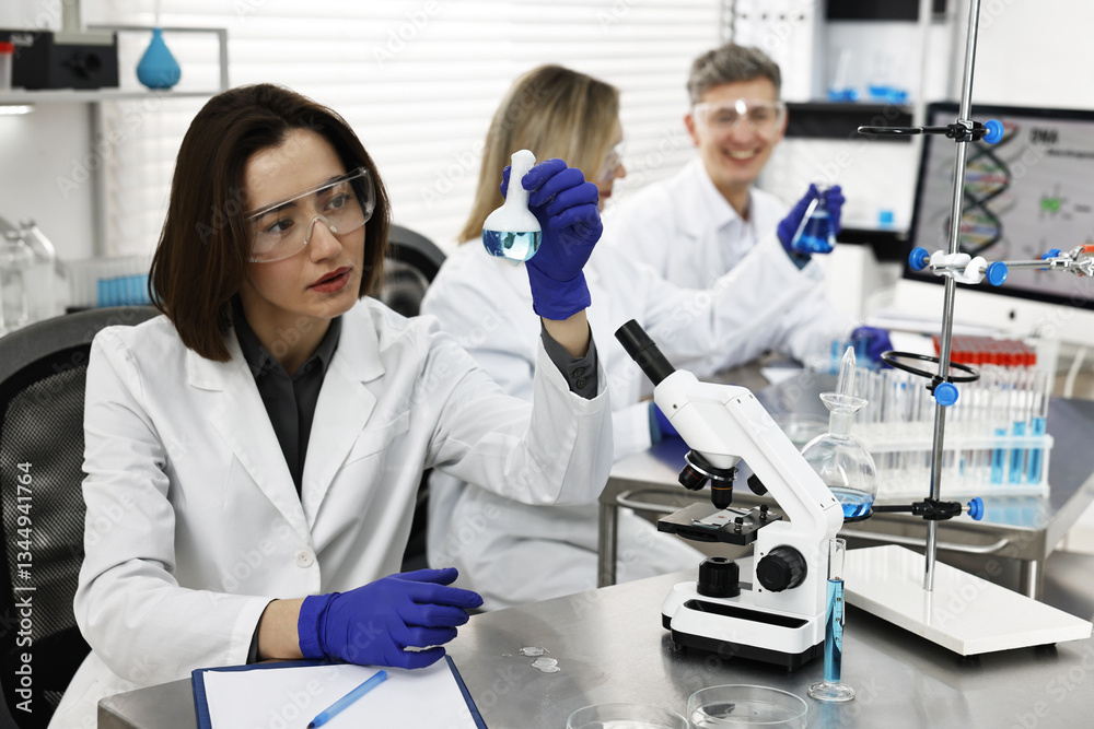 Scientist holding flask with sample in laboratory Scientist holding flask with sample in laboratory