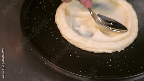 A cook puts mashed potatoes on a plate. Slow motion.
