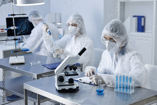 Scientists wearing protective suits while working in laboratory