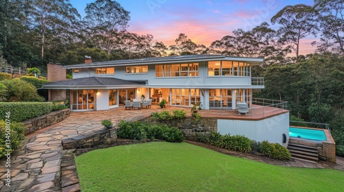 Modern house with pool at sunset in lush forest photo