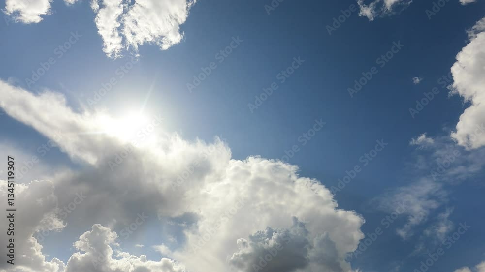beautiful fluffy white cumulus clouds in blue sky summer season. dramatic cloud covered bright sun star in clear good atmosphere, cloudscape time-lapse of powerful sunlight beam, rays in midday,