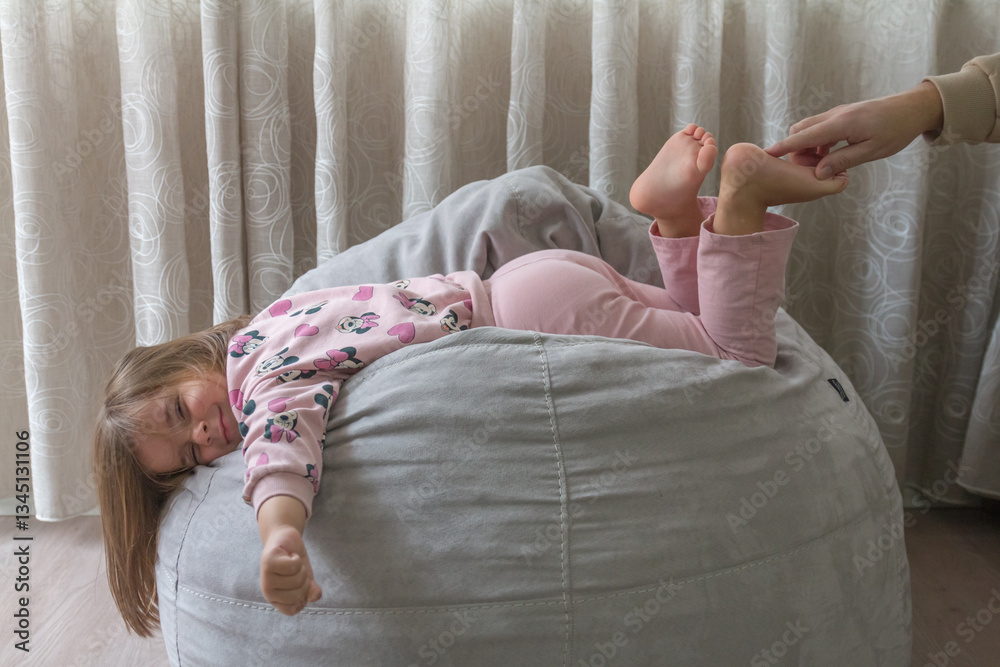 Φωτογραφία little girl trying not to laugh at her father's tickling of her leg,family and l