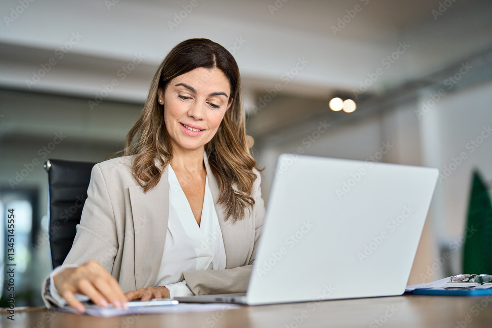 Happy middle aged 45 years old business woman professional hr manager reading cv or finance report overview, lawyer attorney checking document, working on laptop computer sitting at desk in office. Happy middle aged 45 years old business woman professional hr manager reading cv or finance report overview, lawyer attorney checking document, working on laptop computer sitting at desk in office.