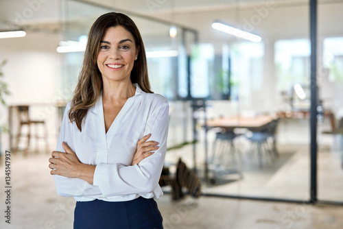Confident middle aged business woman attorney, 45 years old lady entrepreneur, mature female professional executive manager leader standing in modern company office looking at camera. Portrait.
