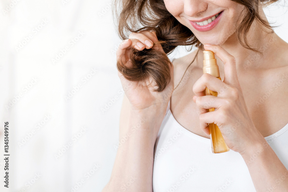 Fototapeta premium Pretty girl applying hair oil to prevent split ends, hair care at home, copy space