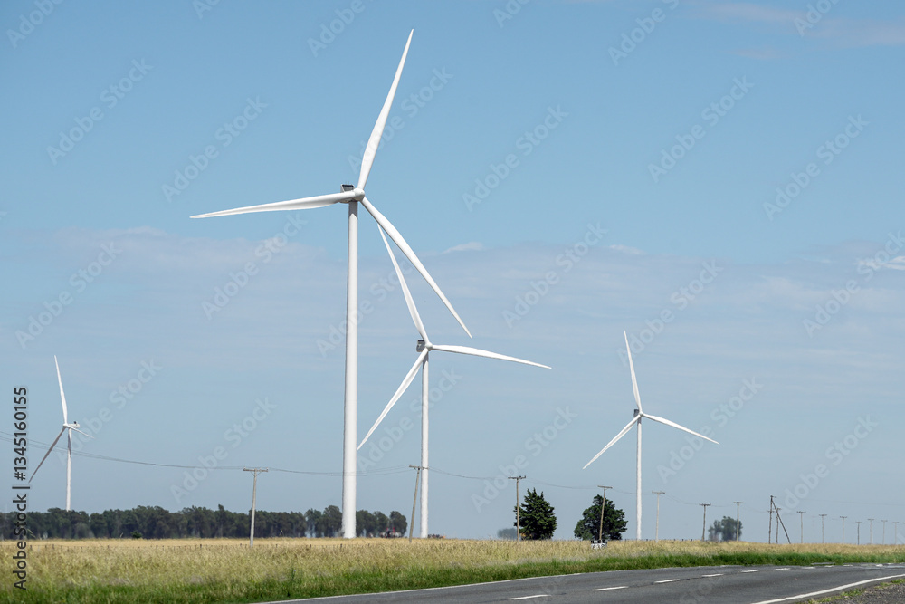 Wind farms with modern white windmills in rural road area Wind farms with modern white windmills in rural road area