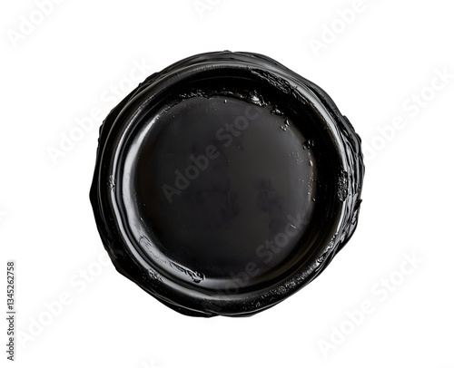 Close-up of a round black sealing wax with a glossy surface on a black background.