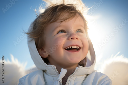  The radiant sun illuminated the clear blue sky, casting a warm glow upon the playful baby boy adorned pristine white outfit