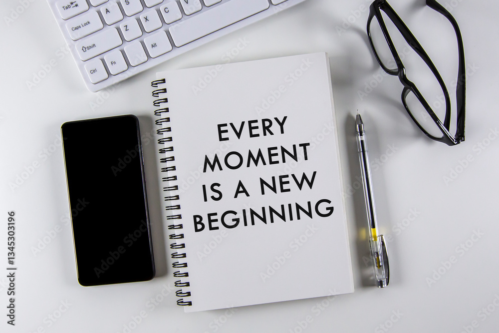 “Every moment is a new beginning†text on notebook with white background.