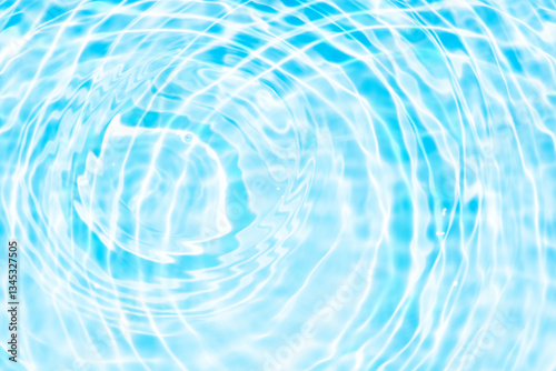 Blue water with ripples on the surface. Defocus blurred transparent blue colored clear calm water surface texture with splashes and bubbles. Water waves with shining pattern texture background.
