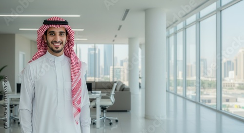 Happy Arab businessman smiling in a modern office with a city skyline view in the background.