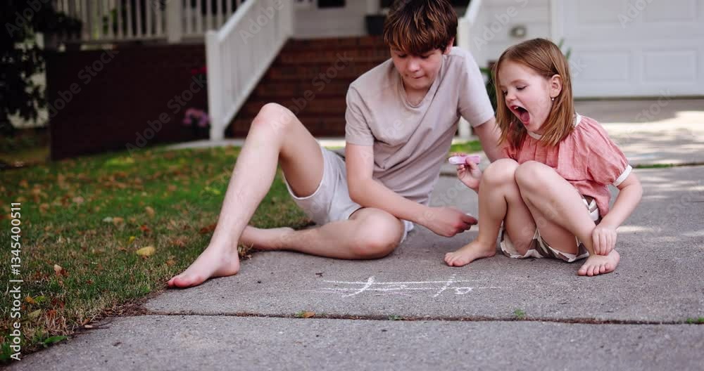 Brother and Sister Playing Tic Tac Toe with Chalk on Driveway – Fun Childhood Game on a Sunny Summer Day in Front Yard. Outdoor Summer Activity in Suburban Neighborhood
