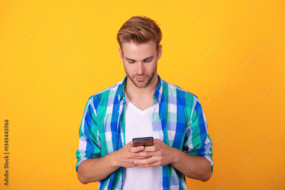 Phone chat. Mobile communication. Communication. Man texting on smartphone isolated on yellow. Millennial man using phone for messaging. Chatting online. Man texting on smartphone