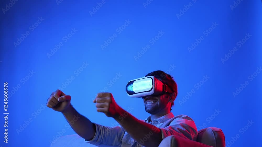 Happy male model using virtual reality goggle to accessing metaverse and playing racing game. Skilled gamer making driving car posture while entering simulated world and wearing VR glasses. Apparatus.