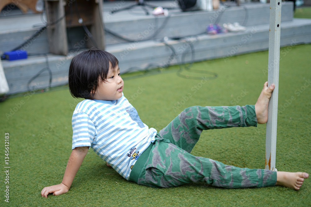 Fototapeta premium 足で棒を掴む男の子/Boy holding a stick with his foot